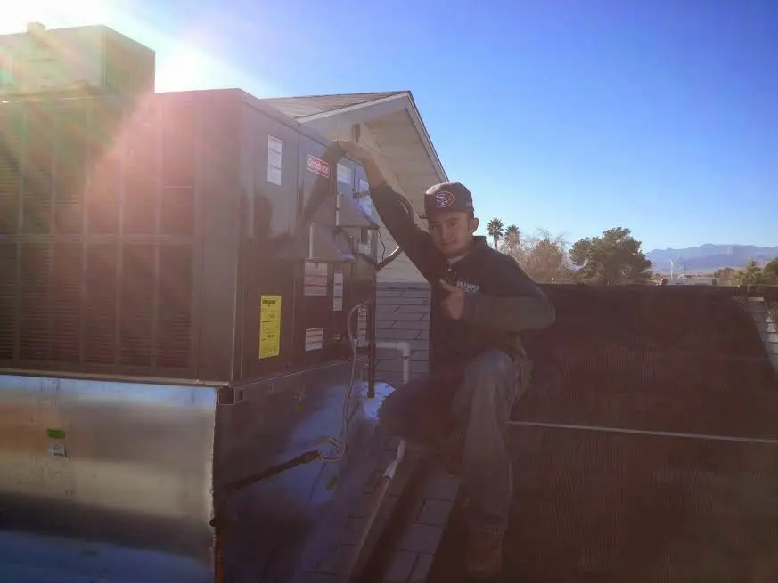 HVAC technician performing AC Tune-Up on a rooftop unit in Amory